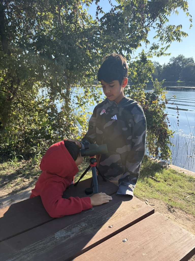 Kids with a spotting scope at the lake
