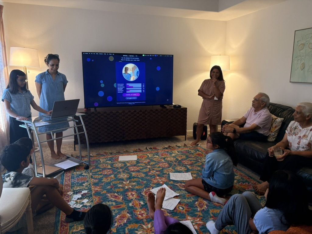 A camper presenting her project on the big screen on Demo Day, families watching