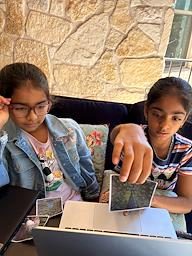 Two campers training an AI model with photos, to distinguish a peacock from a peahen
